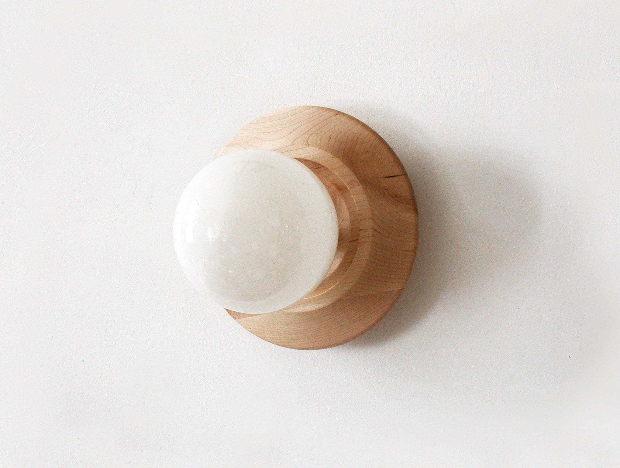 Concave wooden ring and glass globe wall lamp