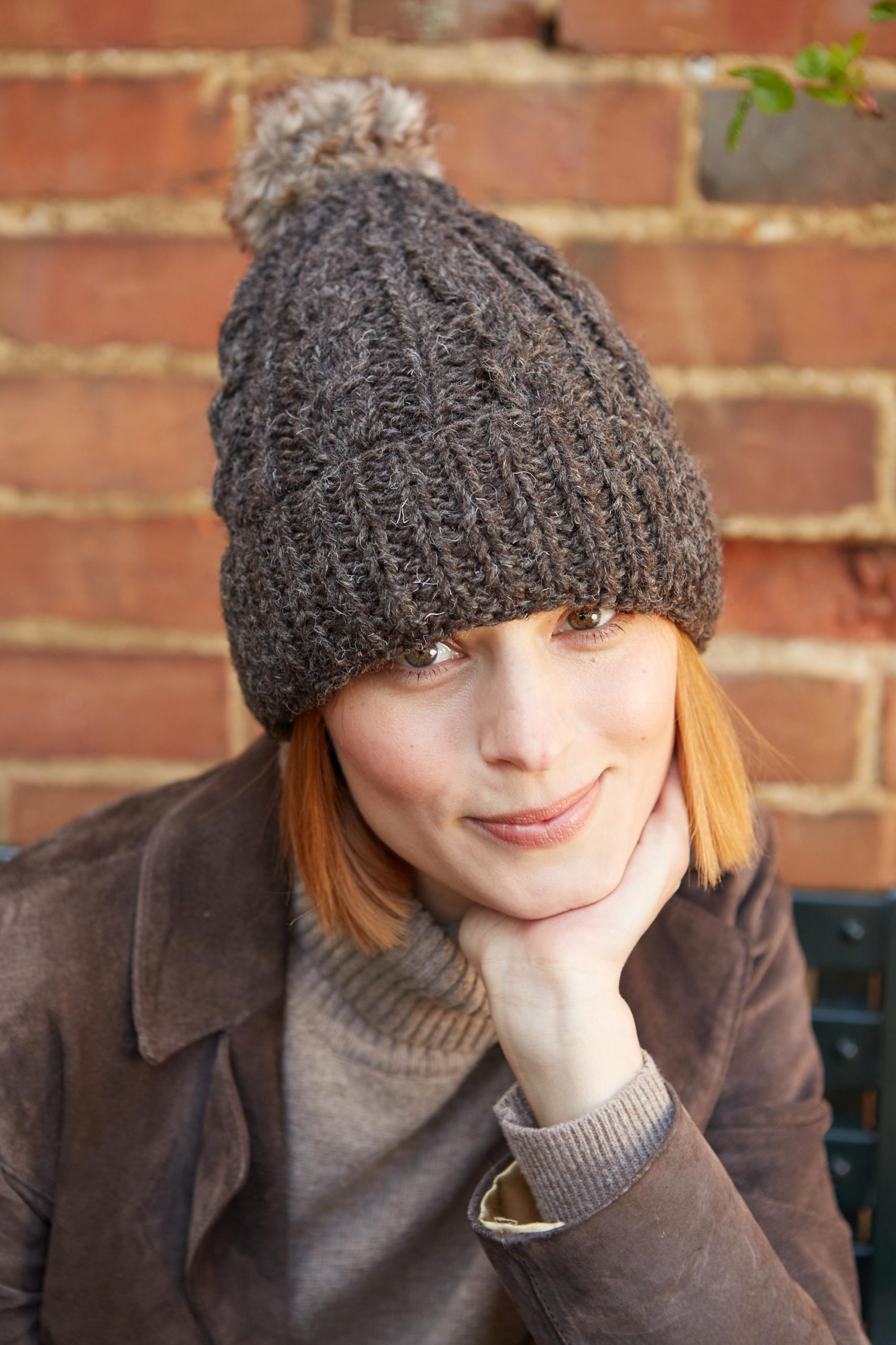 Cocoa-colored cable knit hat with pom-poms