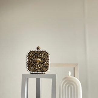 Square clutch bag adorned with gold and pearl trim